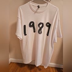 a white t - shirt with black numbers printed on the front and back, hanging from a hanger