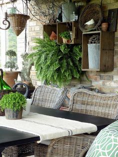 an outdoor patio with wicker furniture and potted plants