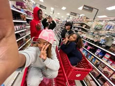 several people are shopping in a store and one person is taking a photo with her phone