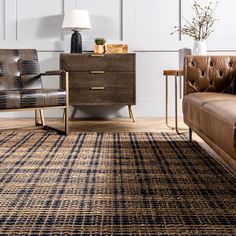 a brown leather couch sitting next to a wooden dresser on top of a hard wood floor