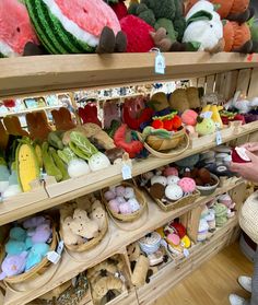 a person standing in front of shelves filled with stuffed animals