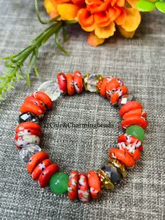 Orange Krobo beads with other glass beads tied on strong glass beads. Handmade Adjustable Rondelle Beads, Red Czech Glass Beaded Bracelets With Colorful Beads, Bohemian Czech Glass Orange Beaded Bracelets, Orange Polished Beads Bracelet, Bohemian Orange Beaded Bracelets With Czech Glass, Bohemian Czech Glass Orange Beaded Bracelet, Bohemian Orange Czech Glass Beaded Bracelets, Polished Heishi Bead Bracelet, Orange Stretch Bracelet With Large Beads As Gift