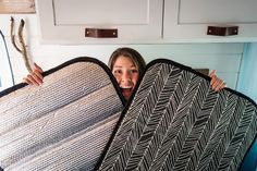 a woman is holding two large blankets in her hands