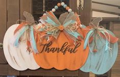 three wooden pumpkins with the words grateful on them hanging from a door hanger