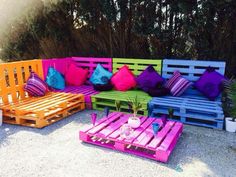 colorful wooden pallet couches and tables in front of some trees with purple pillows