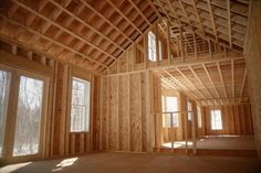 an unfinished room with wood framing and windows