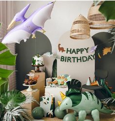 a birthday party with balloons and decorations in the shape of animals, plants and birds