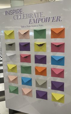 there is a sign that says inspire celebrate emporer with many different colored envelopes on it