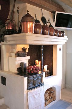 an old fashioned stove with many pots and pans on it's top shelf