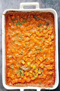 a casserole dish with carrots and parsley