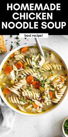 a bowl of chicken noodle soup with carrots and parsley