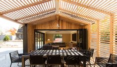 the inside of a house with wooden walls and flooring is furnished with outdoor furniture