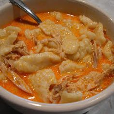 a white bowl filled with soup and dumplings on top of a marble countertop