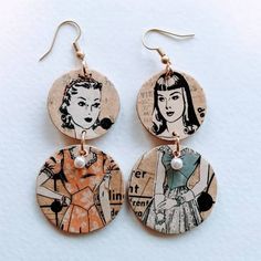 two earrings with pictures of women on them, one is wearing a dress and the other has