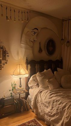 a bed sitting in a bedroom next to a lamp and pictures on the wall above it