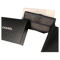 CHANEL Black Caviar Leather CC Logo Long Snap Bifold Wallet 2010 W/Box A stylish pre-owned hardy worn, 2010-2011 Chanel Bi-Fold long wallet handcrafted from luxurious black grained caviar calfskin leather with silver hardware. Black colour, large CC stitched logo, grosgrain interior with 7 card slots, 4 notes slots, closure with leather snap press stud with Chanel stamp. Another compartment for coins closes with snap press stud with Chanel stamp. This grained caviar leather is very resistant for Button Closure Flap Card Holder Chanel With Pocket In Back, Chanel Flap Card Holder, Chanel Classic Card Holder, Vintage Chanel Wallet, Luxury Designer Black Wallets, Black Packaging, Black Chanel Wallet, Chanel Box, Black Caviar