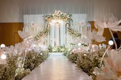 the aisle is decorated with flowers and greenery