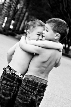 two young boys hugging each other in front of a black and white photo with the caption pin it