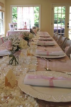 the table is set up for a formal function with pink and white flowers on it