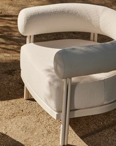 a white chair sitting on top of a sandy beach