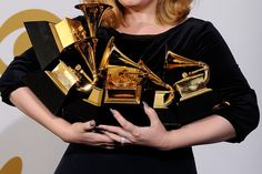 a woman in black dress holding an award for best female vocal performance at the 59th annual grammy awards