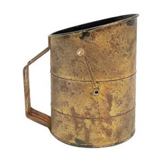 an old, rusty metal cup is shown against a white background with the handle missing