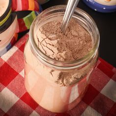 a jar filled with brown powder sitting on top of a red and white checkered table cloth