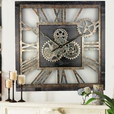 a clock made out of metal with gears on it's face is displayed in front of a fireplace mantel