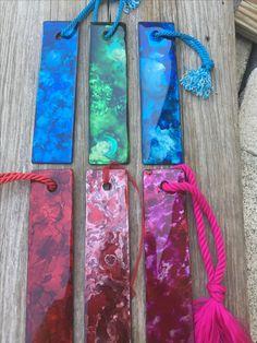 four different colored bookmarks with tassels on them