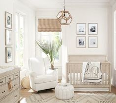 a baby's room with white furniture and pictures on the wall