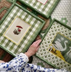 a person is looking at some pictures on the floor with their hands in front of them