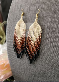 two pairs of beaded earrings on a mannequin