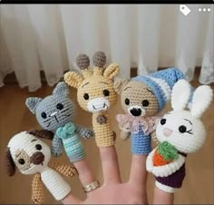 there are many small crocheted animals on this hand and one is holding the finger