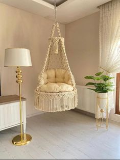 a living room with a hammock hanging from the ceiling next to a lamp