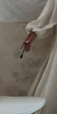 a person using a brush to paint a wall