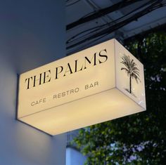 the palms cafe sign is lit up at night