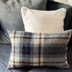 two pillows sitting on top of a gray couch