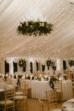 a banquet hall with tables, chairs and chandeliers