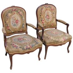 two chairs with floral designs on them sitting next to each other