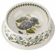 a white bowl with blue flowers and green leaves