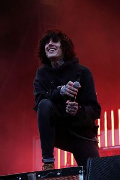 a man sitting on top of a stage holding a microphone