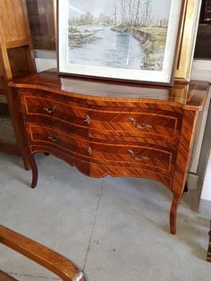 an old dresser with a painting on it