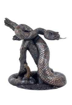 a statue of a snake on top of a tree branch with its tail curled up