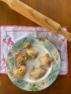 small pastries on a plate next to a wooden spoon and cloth with floral designs