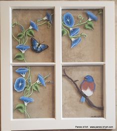 four blue flowers and two butterflies in a shadow box