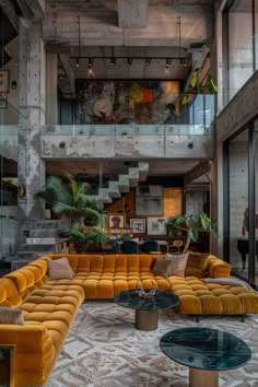 a living room filled with yellow couches and lots of windows next to a staircase