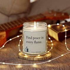 a candle that is sitting on a table next to some string lights and a guitar