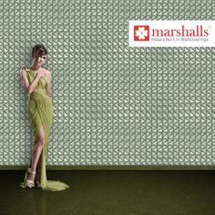 a woman in a green dress leaning against a wall with the words marshalls on it