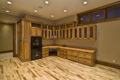 an empty kitchen with wooden cabinets and wood floors