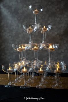 many wine glasses with candles in them are arranged on top of each other and placed together